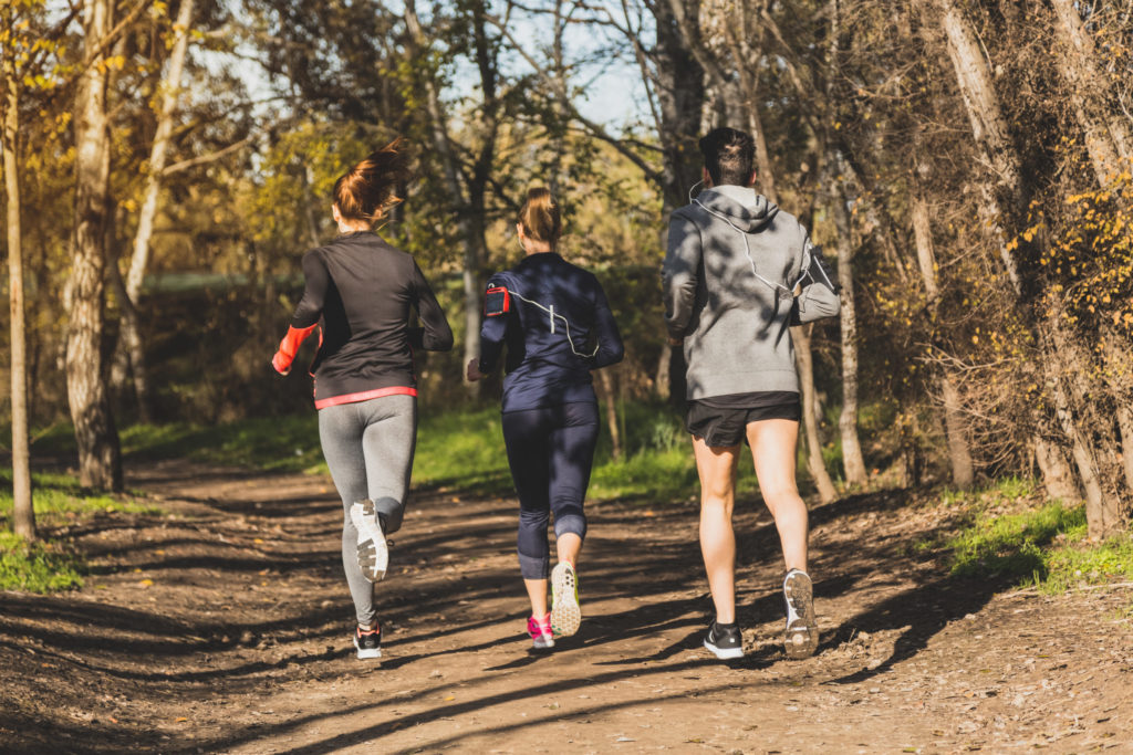 Vue arriere de gens courir dans le parc